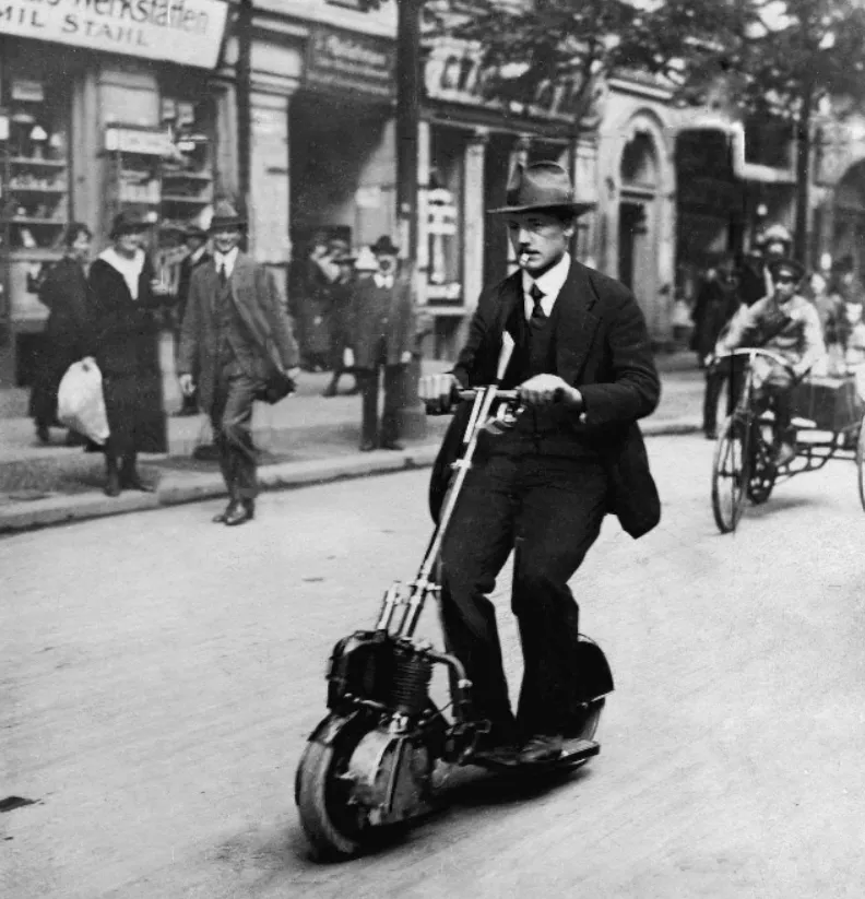 Fotografie vintage di persone che guidano scooter elettrici dell'inizio del XX secolo