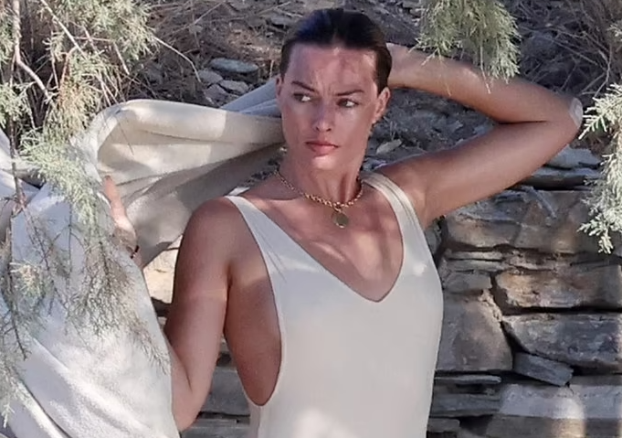 Margot Robbie looks sensational in a plunging white bathing suit as she packs on the PDA with husband Tom in Greece