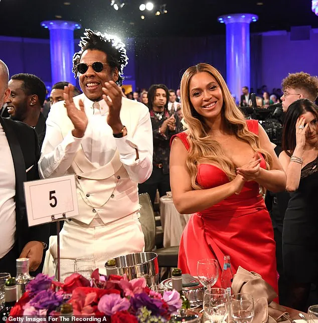 Beyonce puts on a busty display in a plunging scarlet gown as she joins dapper husband Jay Z at the Clive Davis pre-Grammy Gala