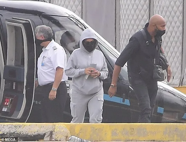 Beyonce was seen covering up as she left The Hamptons by helicopter for New York City and was accompanied by a muscular bodyguard on the trip