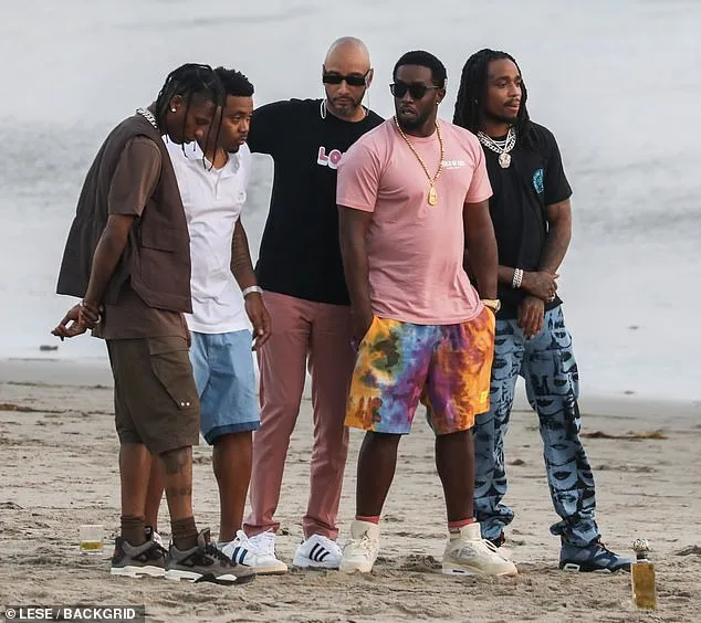 Diddy rocks a hefty gold chain as he poses for photos on the beach with rap colleagues Travis Scott, Quavo, Swizz Beats, and Nas in Malibu
