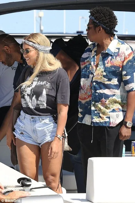 Beyonce rocks a baggy t-shirt and skinny denim as she sails to Nice with Jay-Z amid pregnancy rumours - as she promotes her husband in a Jay Z top paired with her own branded earrings