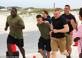 Heartwarming moment Marine carries cancer survivor, 11, across triathlon finish line after boy's prosthetic leg breaks
