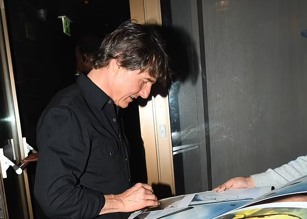 Tom Cruise looks every inch the Hollywood heartthrob as he's mobbed by fans and signs autographs leaving restaurant in London