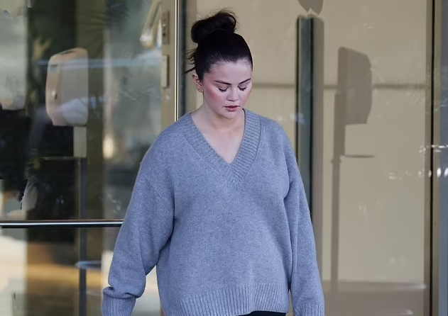 Selena Gomez models an oversized sweater while leaving an office building in Los Angeles... before the release of her new single Love On