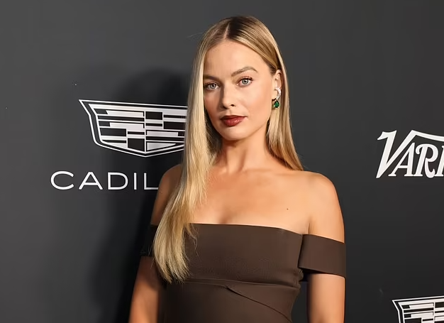 Margot Robbie stuns in a fitted brown frock as she makes a rare red carpet appearance alongside her husband Tom Ackerley in Los Angeles