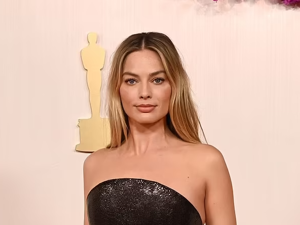 Margot looked absolutely beautiful in a shimmery sequin black Versace gown, which featured a rounded neckline and a ruching detail along her waist